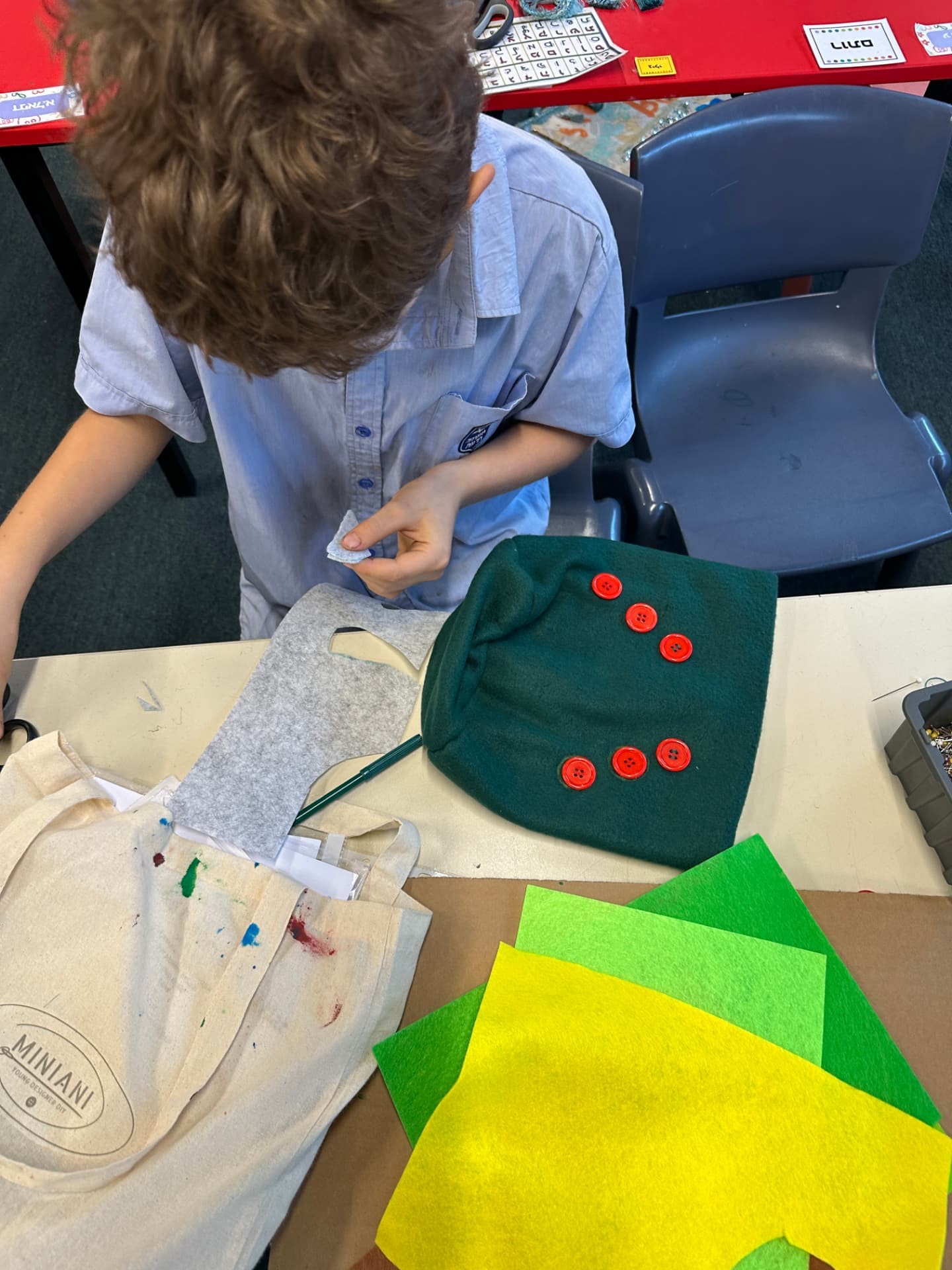 A young designer sewing a fabric project at a workshop table