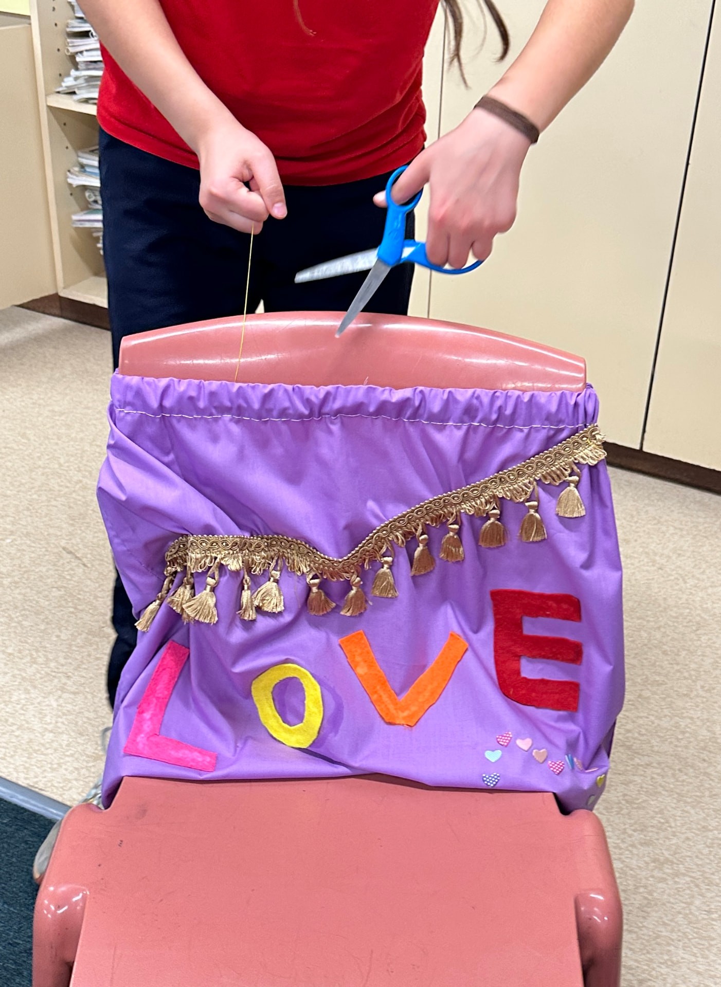 A purple handmade bag decorated with colourful LOVE lettering