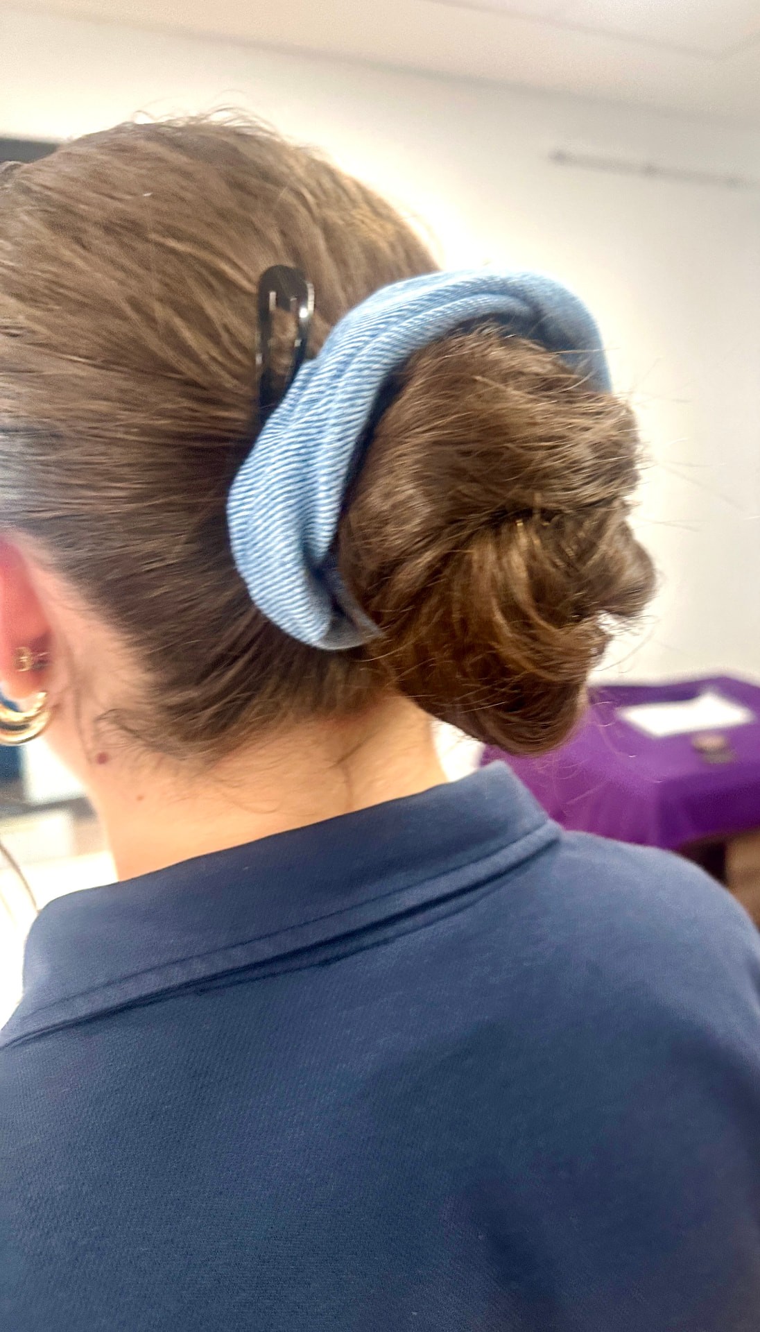A handmade blue denim scrunchie worn in a bun