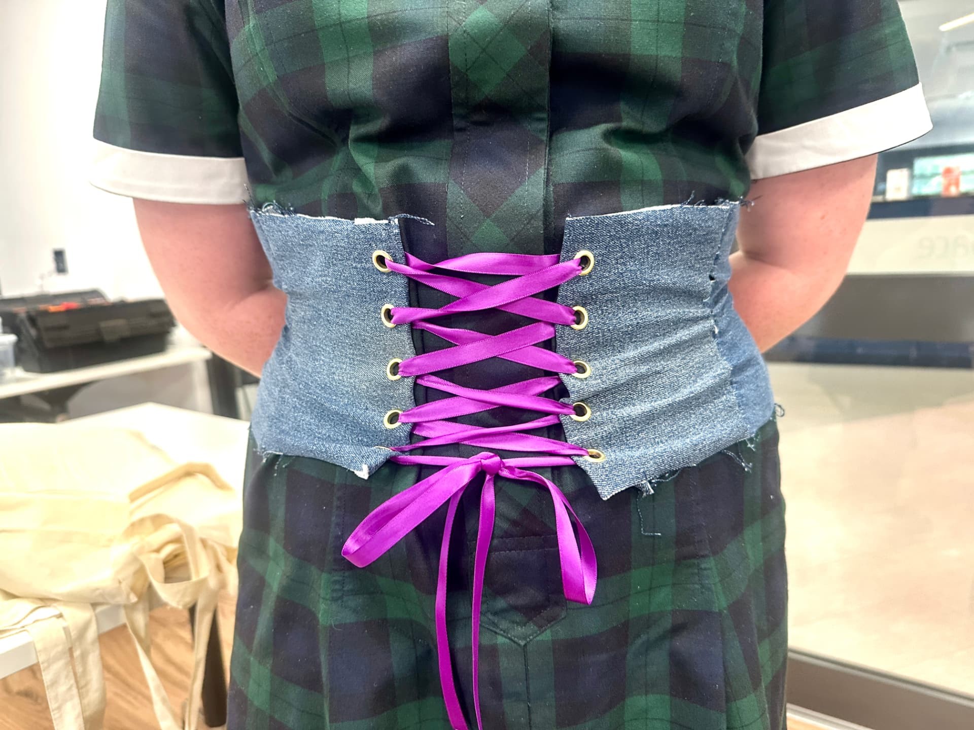 Handmade denim corset with bright pink lacing
