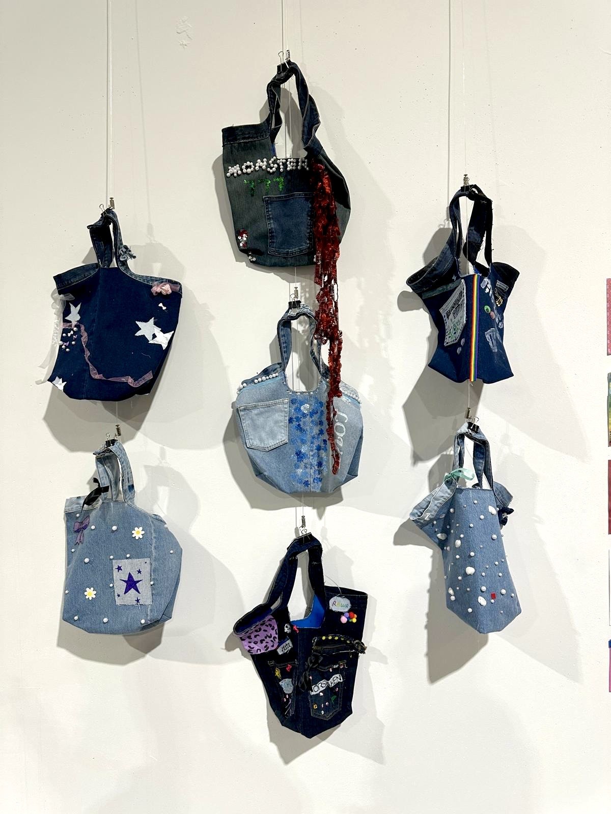 Handmade denim bags displayed on a wall