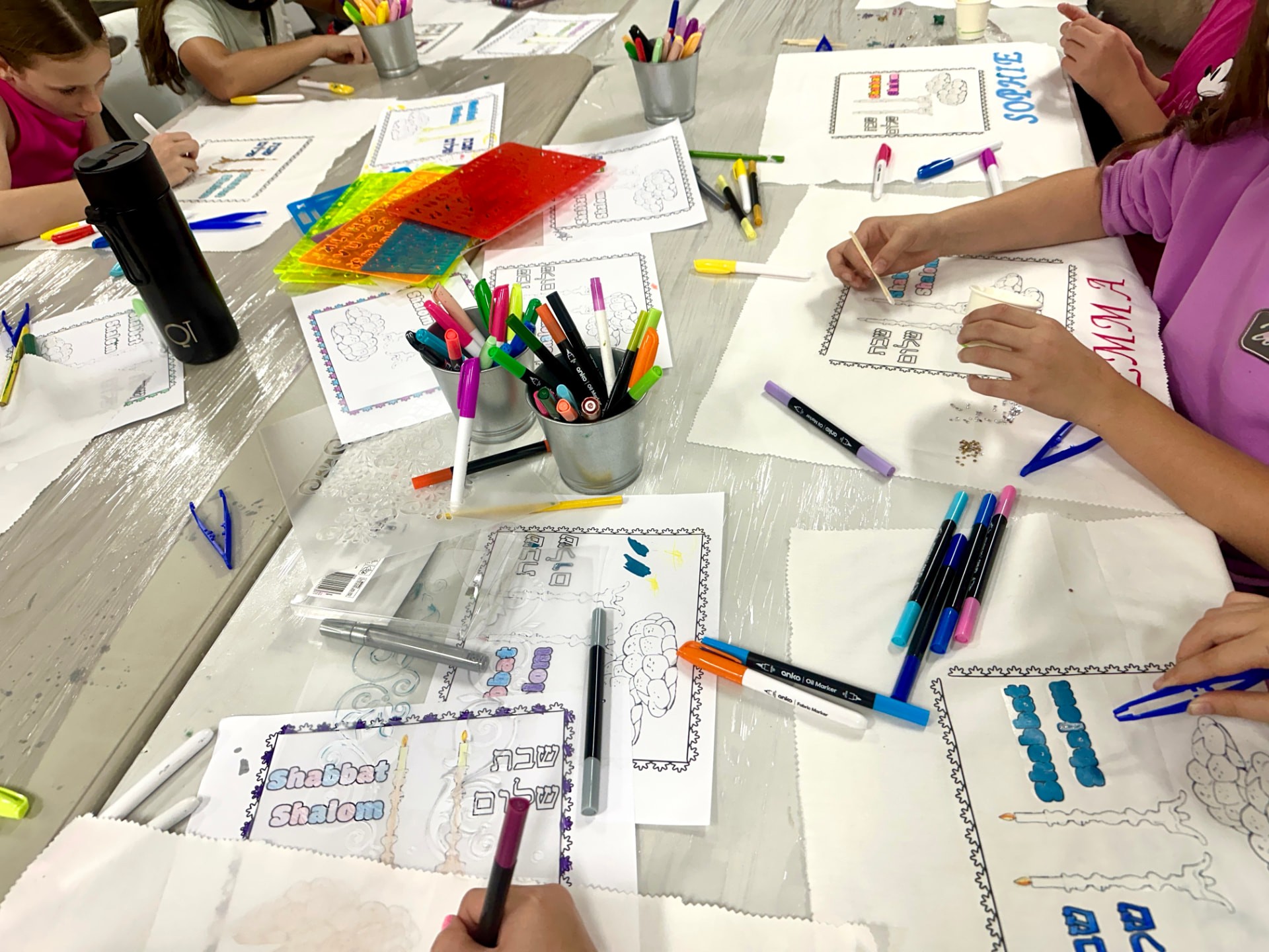 Sketchbooks, fabrics and drawing tools on a workshop table